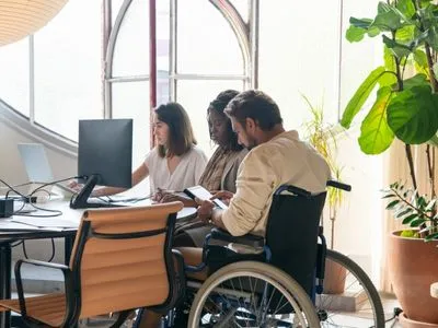 Une personne en fauteuil roulant travaille dans un bureau - Devenir Formation